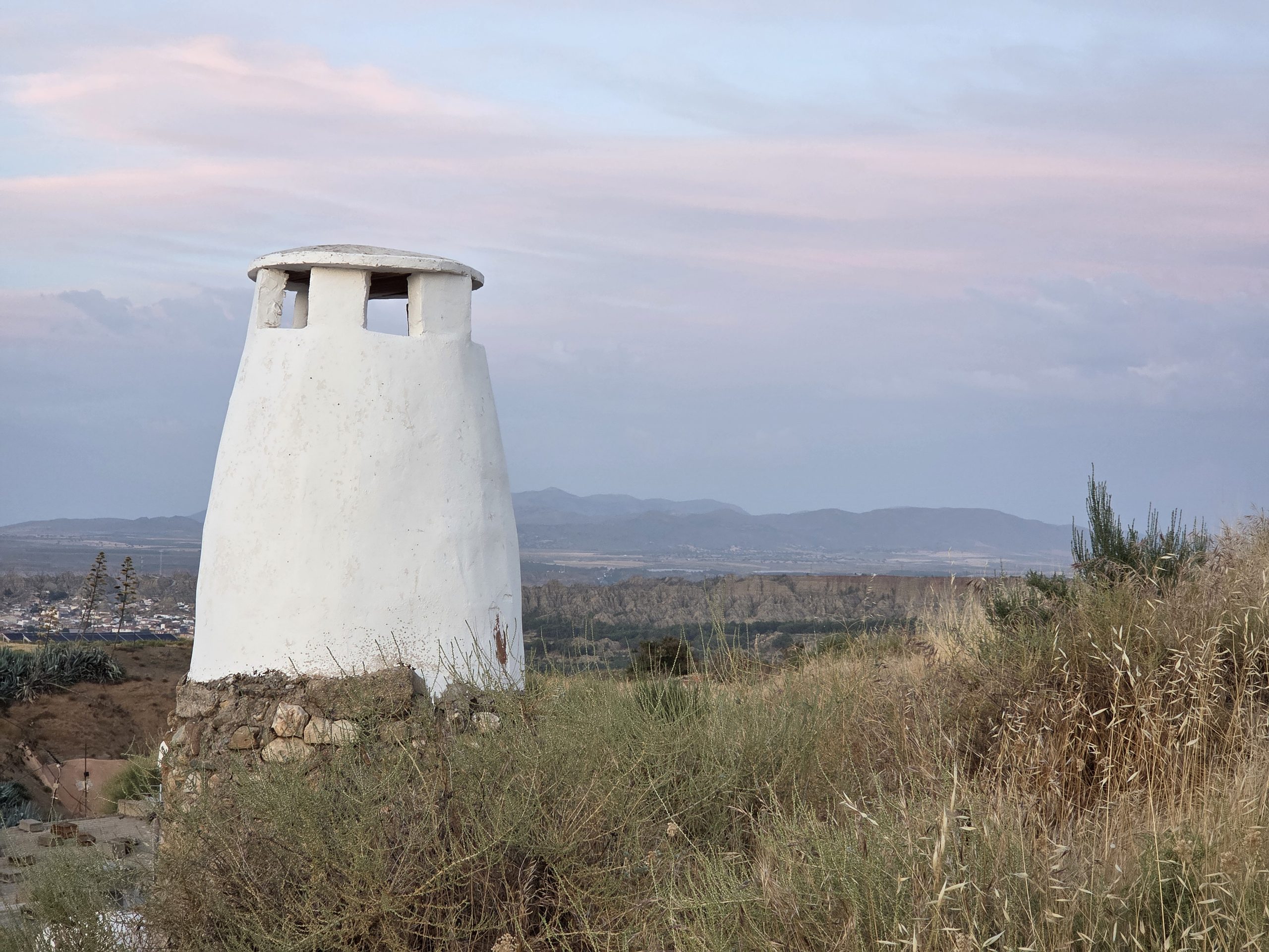 La chimenea es el elemento repreentativo de las casas cuevas en el paisaje de barrios con esta vivienda troglodita tradicional de la Comarca de Guadix.